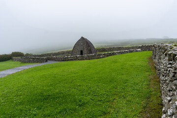 landscape view of the Gallarus Oratory early-Christian church in County Kerry on a foggy morning