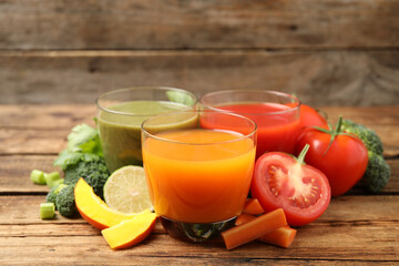 Delicious vegetable juices and fresh ingredients on wooden table