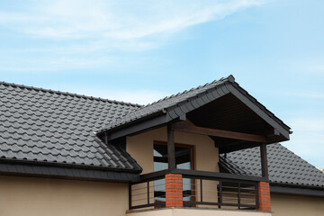 Fototapeta na wymiar Beautiful house with grey roof against blue sky