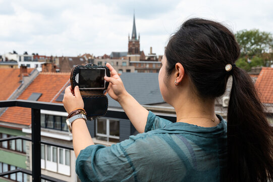 Portrait Of A 32 Year Old Japanese Woman, Taking A Photo With Her Smartphone