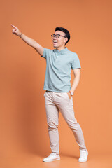 Fototapeta na wymiar Full length image of young Asian man standing on backgound