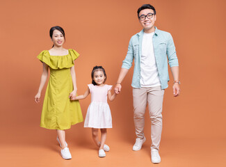 Young Asian family posing on background