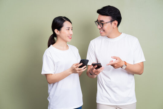 Image of young Asian couple using smartphone