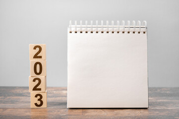 Mockup 2023 calendar. Text 2023 on wooden cubes. space for your text on notepad, mockup calendar....