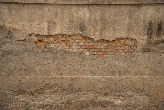Particolare di muro vecchio con cemento rovinato e mattoni in vista