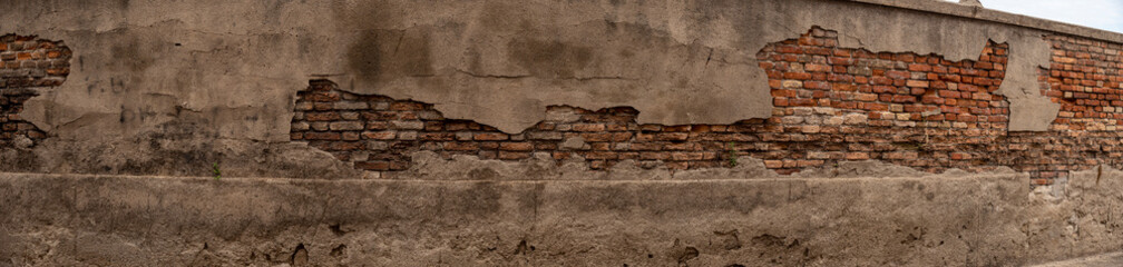 Panoramica di muro in mattoni rovinati in città