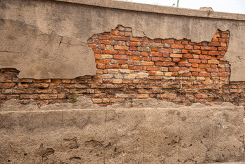 Cemento scrostato su vecchio muro con mattoni a vista