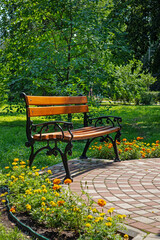 Bench made of wood and metal in a city park in the summer on a sunny day