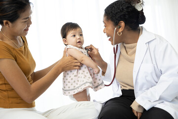 Obraz premium mother and her baby visit to the doctor and examining baby girl in clinic