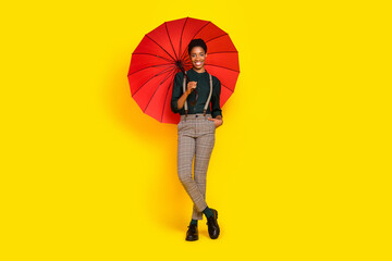 Full length body size view of attractive cheerful woman holding parasol isolated over vibrant yellow color background