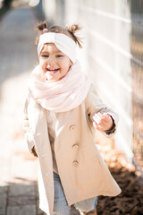 Fototapeta premium Portrait of cute little girl smiling and running