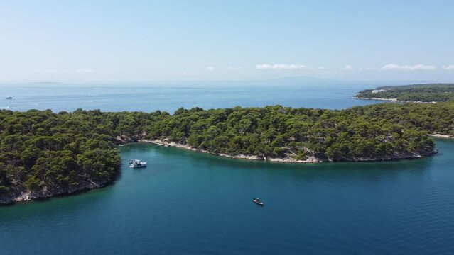 anchored tourist boats on the calm waters of the Adriatic Sea, Croatia, late morning, mid-summer, no wind, view from a drone, Rab island archipelago