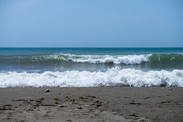 Fototapeta na wymiar Ocean waves crashing on sandy beach. Sea waves breaking on Maditerranean's shore.