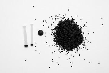 Recyclable thermoplastic elastomer granules for medical syringe on white background