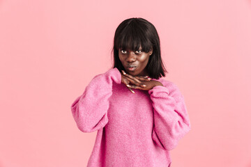 Young cute african lady in pink sweater with intertwined fingers