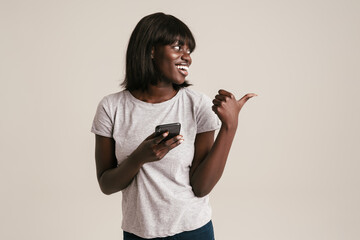 Young beautiful smiling african woman with bob haircut holding phone
