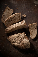 Low key food photography. Black rustic bread on dark background - 524046300
