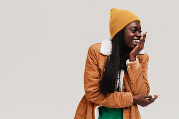 Young beautiful long-haired laughing african woman in winter hat