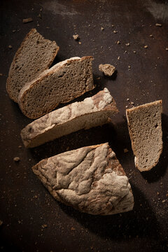 Low key food photography. Black rustic bread on dark background