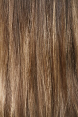 Hair coloring women close up texture background. Bunch of shiny straight blond hair in a wavy curved style. Copy space.