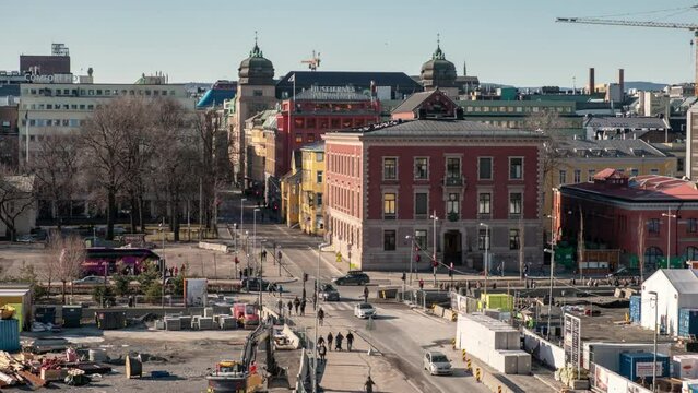 Crowded people walking and traffic at the crossroad in central city with traditional buildings at Oslo, Norway