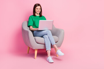 Full length portrait of cheerful pretty person sit chair use wireless netbook isolated on pink color background