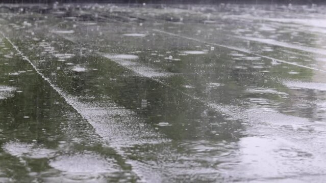 Raindrops knock on the roof, heavy rain, downpour. The flat roof of the building is covered with a waterproof material that protects from rain. Ruberoid, rolled roofing and waterproofing material.