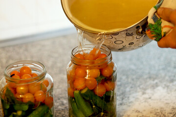 The process of preserving cucumbers and tomatoes for the winter. selective focus