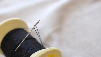 sewing reel and needle on fabric
