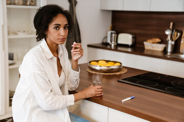Young black woman being upset and taking abortion pill at home