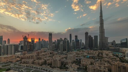 Sunset over Dubai Downtown timelapse with tallest skyscraper and other towers view from the top in Dubai, United Arab Emirates. Rays of light and cloudy orange sky
