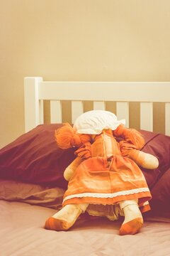 Rag doll spread-eagled face down on a bed