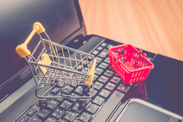Grocery basket and shopping cart on laptop. Worldwide online shopping b2c e-commerce on internet...