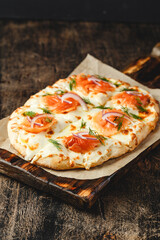 Roman-style pizzas with salmon. Roman square pizza or Pinsa on thick dough, Italian Cuisine