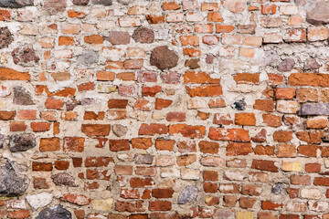 Solid background of red bricks and stones. Old building wall background