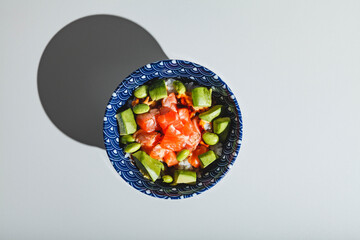 Poke bowl with rice, avocado, edamame beans and smoked salmon. Hard light, deep shadow