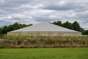 Concrete manure silo in a meadow in the north of the Netherlands. - obrazy, fototapety, plakaty