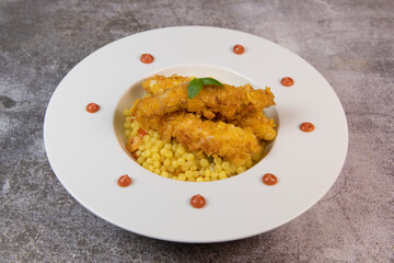 Recipe for chicken tenders with corn flakes and Italian Piombo pasta risotto and peppers. High quality photo