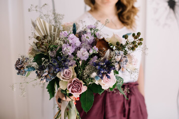 Very nice young woman holding big and beautiful bouquet of fresh roses, matthiola and other flowers in purple colors, cropped photo, bouquet close up - 524072598
