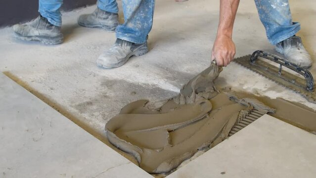 Bricklayer applying cement glue with a trowel