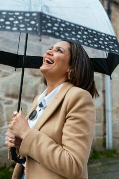 Happy female laughing under umbrella
