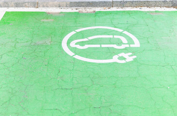 Electric vehicle charging station sign on painted asphalt road