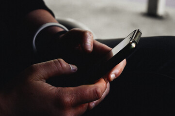 Persona usando teléfono inteligente con las dos manos.