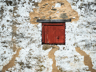 
Old textured wall with red wood window