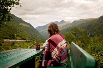 Young woman enjoying the amazing views in Norway to fjords, mountains and other beautiful  nature,...