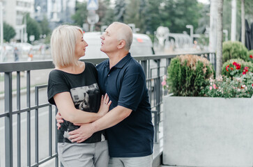 a man and his wife in black T-shirts are hugging in the city