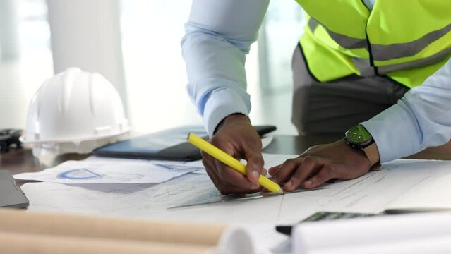 Hands of professional design, architect engineer drawing with graphic tools, construction plans blueprint. Closeup of an industrial designer working on illustration for new modern building project