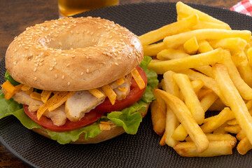bagel au poulet et frites dans une assiette
