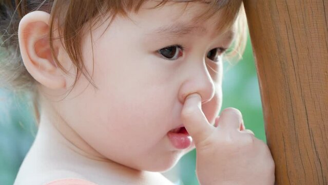 Little girl picking her nose