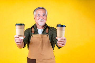 Portrait charming retired asian elder man has a white mustache and beard wearing apron hold paper cup of coffee.
